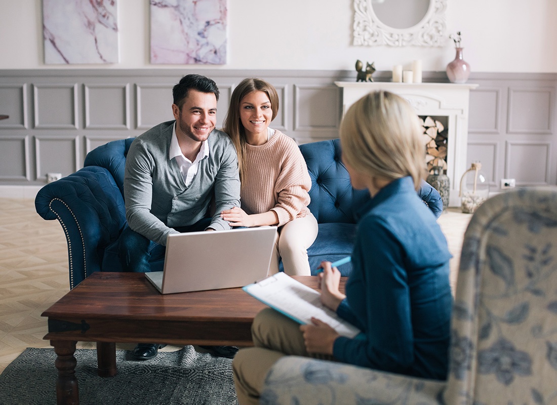 About Our Agency - Happy Couple Sit Down Together and Speak With an Agent in Her Office