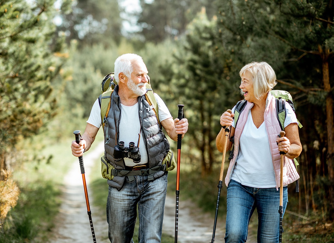 Medicare - Happy Elderly Couple Hiking Together in a Park